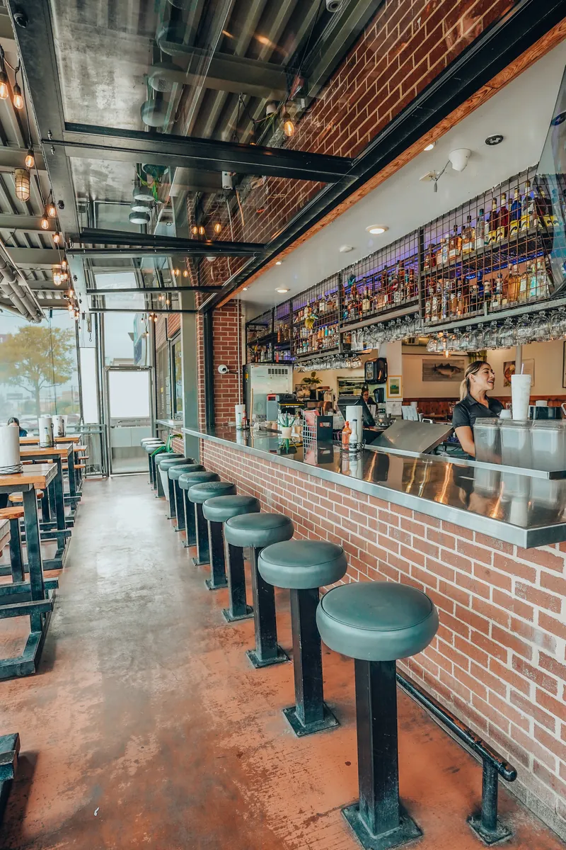 The bar with its brick wall and green stools