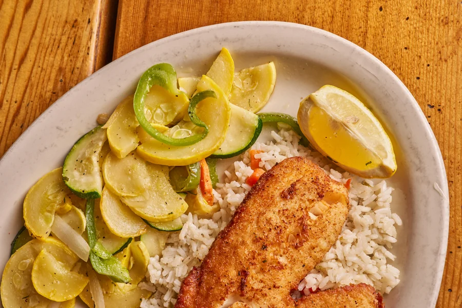 Golden fish fillet with rice and sautéed vegetables